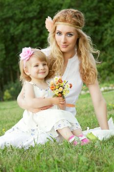 Romantic mother and baby girl sitting on grass