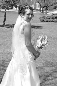 A bride holds her flower bouquet in her hands.