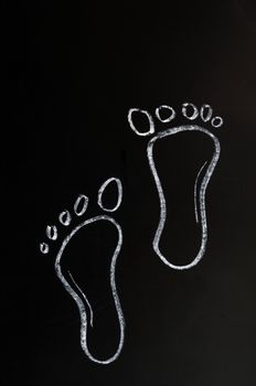 Footprints drawn with white chalk on a blackboard
