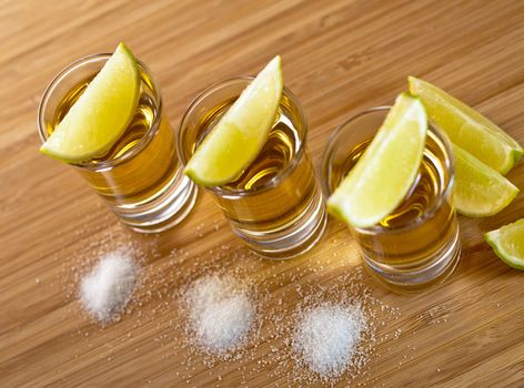 Three shots of tequila with lime and salt