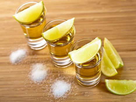 Three shots of tequila with lime and salt