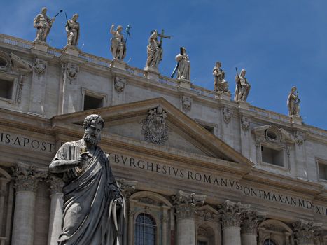 View of the facade of The Papal Basilica with the statue of Saint Peter in front.