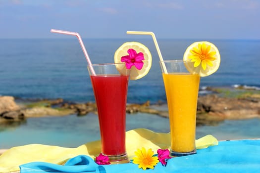 red and yellow fruit cocktails on the background of beautiful sea landscape