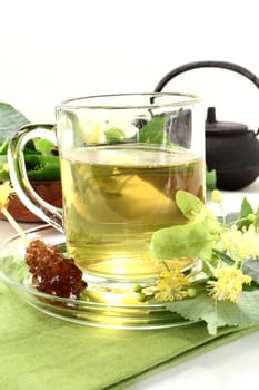 a cup of lime blossom tea with fresh flowers