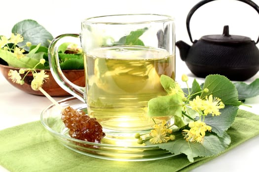 a cup of lime blossom tea with fresh flowers