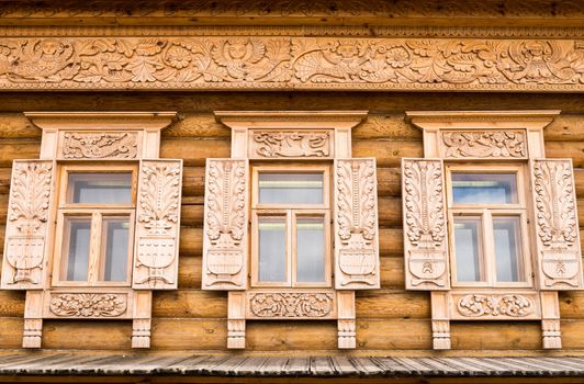 Wooden decorated windows in log house, Russian traditional architecture.