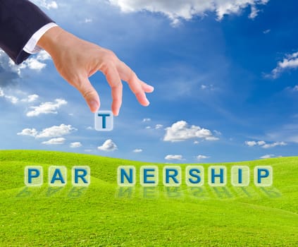 business man hand and partnership word on green grass meadow