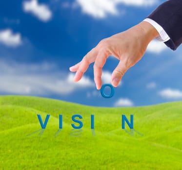 business man hand and vision word on green grass meadow