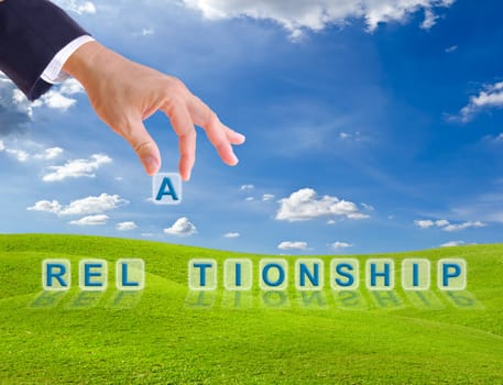 business man hand and relationship word buttons on green grass meadow