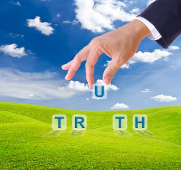 business man hand made truth word buttons on green grass meadow