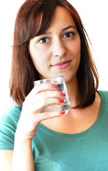 portrait of young caucasian brunette woman with glass in hand drinking water