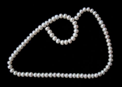 White pearls on the black silk can use as background 