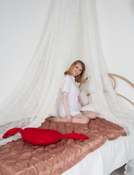 sexy woman doctor on the bed with a toy heart