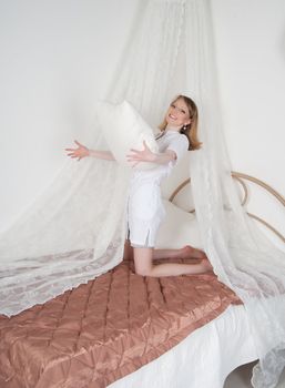 sexy woman doctor on the bed throwing pillows