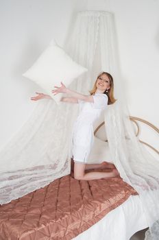 sexy woman doctor on the bed throwing pillows