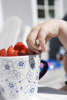 Baby Girl stealing Strawberries close-up