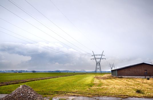 view on Dutch farm with fields and high voltage line