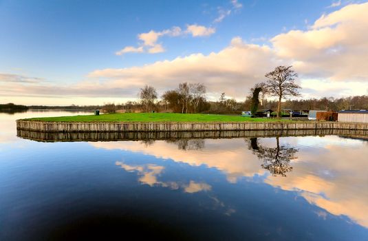 symmetry and reflection of blue sky with white clouds in the lake