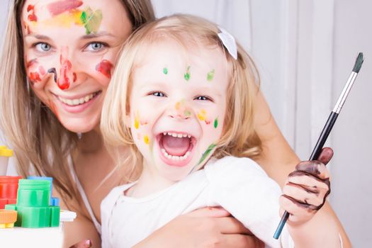 Happy mother and daughter with paint on faces