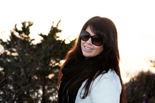 Portrait of an attractive brunette woman with intentional lens or sun flare.