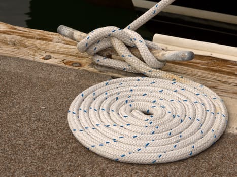 Closeup view of boat rope tied to cleat on dock