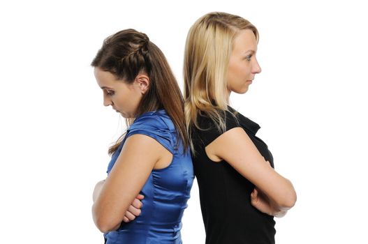 Two young attractive women standing back to back. Isolated on white.