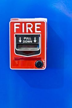 fire alarm switch on blue wall