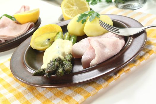 Asparagus with hollandaise sauce, potatoes and cooked ham