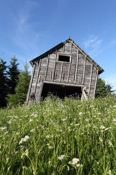 Photo of an old barn leaning over and about to collapse.