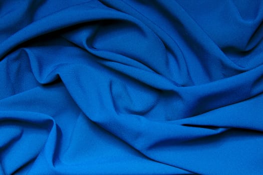 The folds of a bright blue cloth. Abstract Background