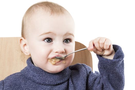 baby eating applesauce - studio shot isolated on white background
