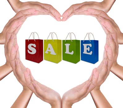 sale label on shopping  paper bag in hands heart
