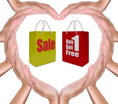 sale label on shopping  paper bag in hand heart