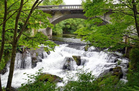 Stone bridge over forest and waterfalls