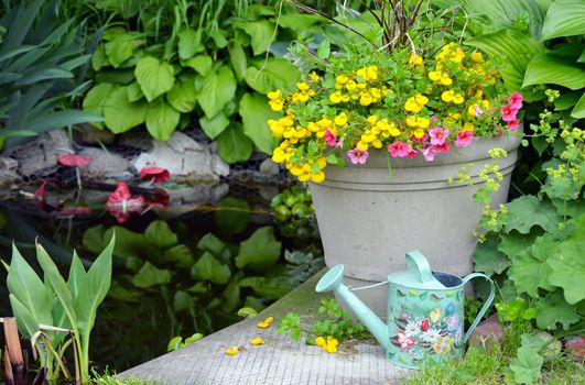 Planter full of colorful flowers next to pond