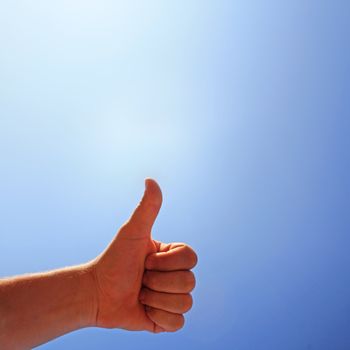 men's hand make thumbs up on blue sky