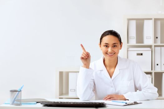 Young female doctor in white uniform at workplace