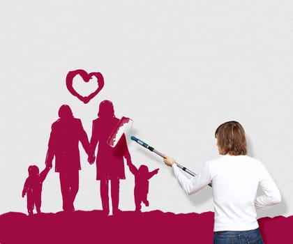 Young man with a paintbrush and family picture on the wall