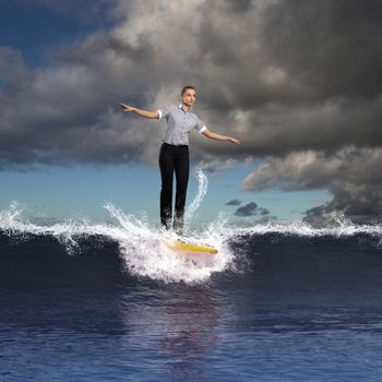 Image of young business person surfing on the waves of the ocean