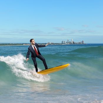 Image of young business person surfing on the waves of the ocean