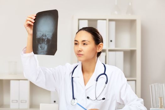 Young female doctor in white uniform at workplace