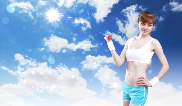 Portrait of a young woman doing sport against blue sky