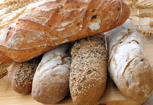 Varied with ears of wheat bread on a wooden board