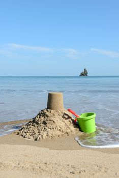 beautiful  sunny day at the beach with Sandcastle, bucket and spade