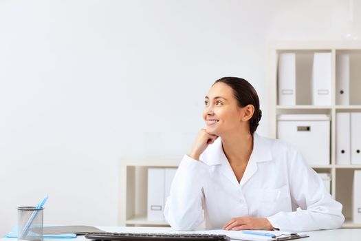 Young female doctor in white uniform at workplace