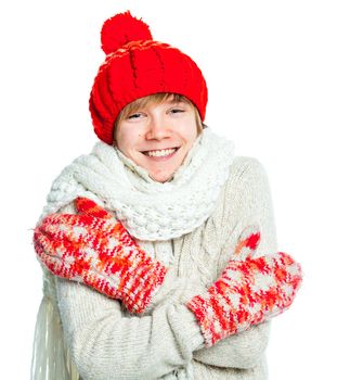 Portrait of young smiling cute frozen teenager in a red hat and mittens, isolated on white