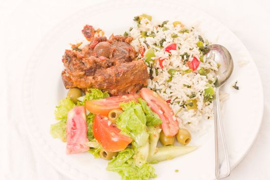 Roast lamb served with rice and vegitables with salad on the side