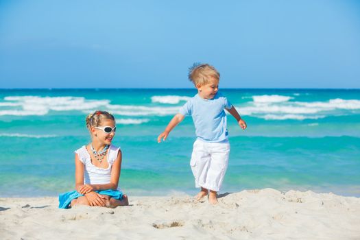 Young beautiful girl and boy playing happily at pretty beach. Majorca