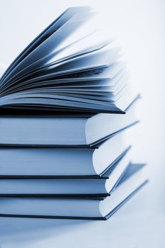 pile of books with one book open