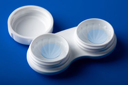 blue contact lens in white container
